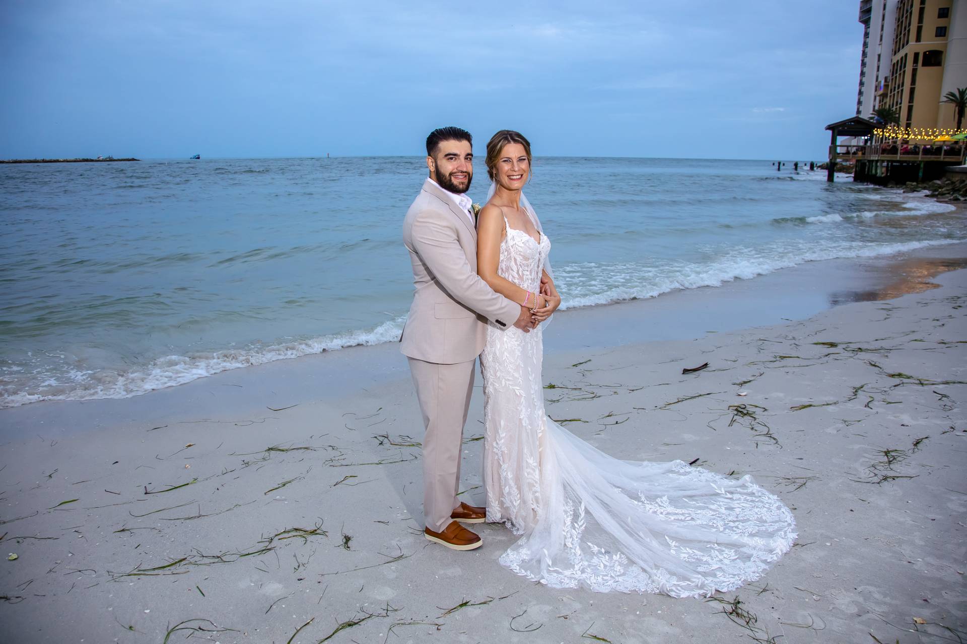 bride and groom looking at each other standing on the beach at sunset