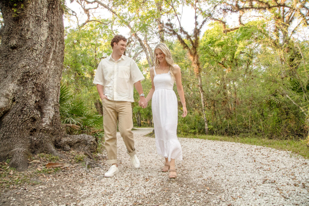 a couple walking hand in hand along a rocky path in the park