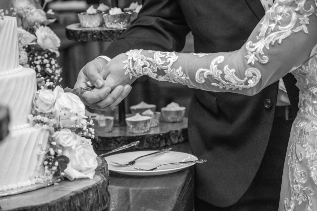 bride and grooms hands cutting their wedding cake