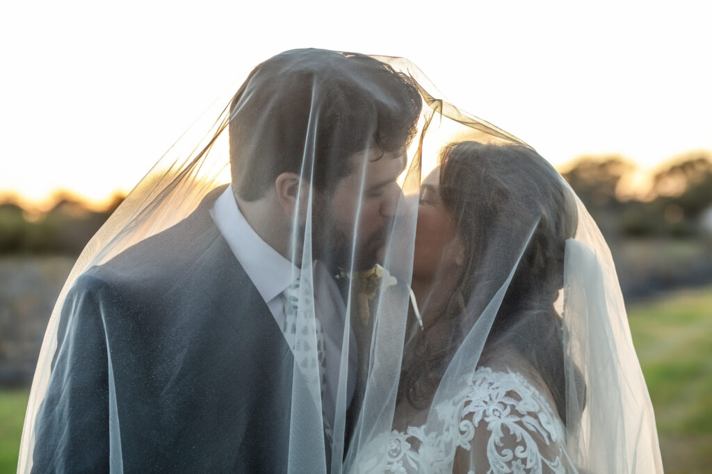 bride and groom kissing under her veil
