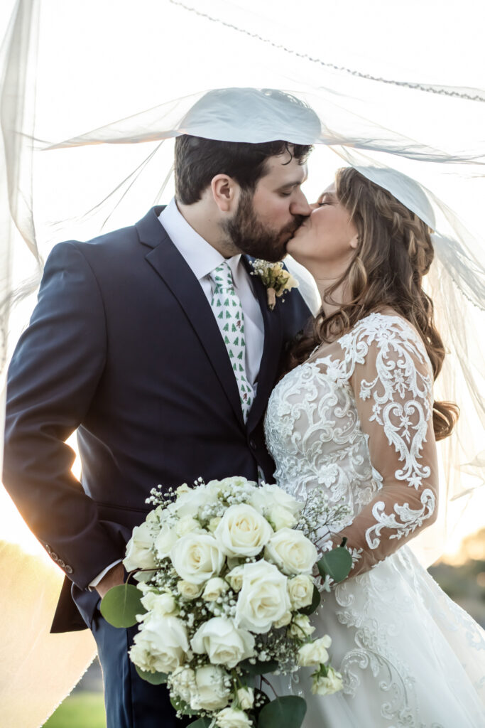 bride and groom kissing under her veil