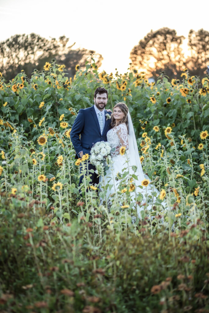 bride and groom looking at each other in the middle of a sunflower field