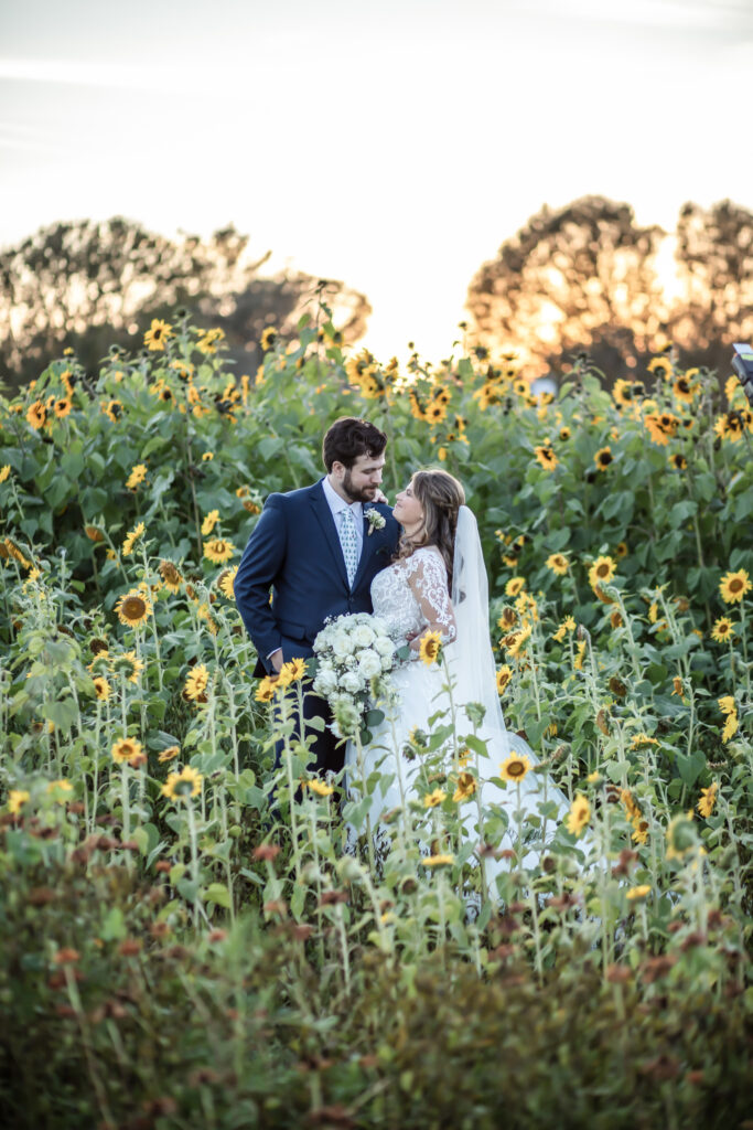 bride and groom looking at each other in the middle of a sunflower field