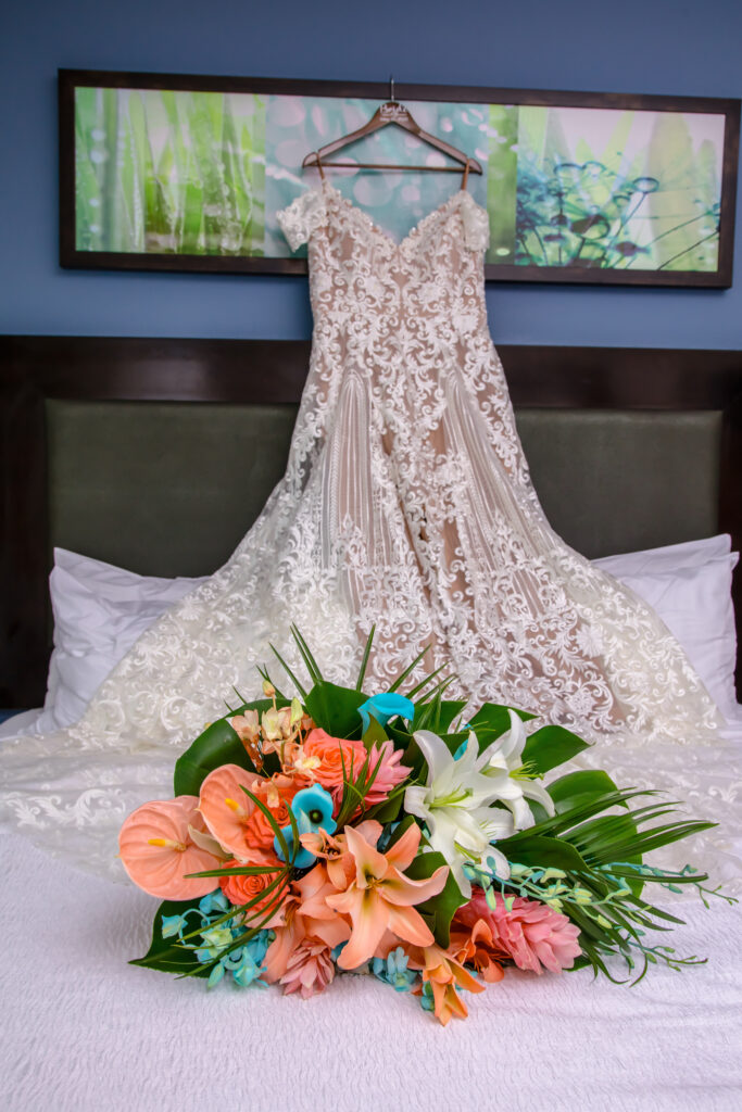 brides wedding dress with her flowers on the bed