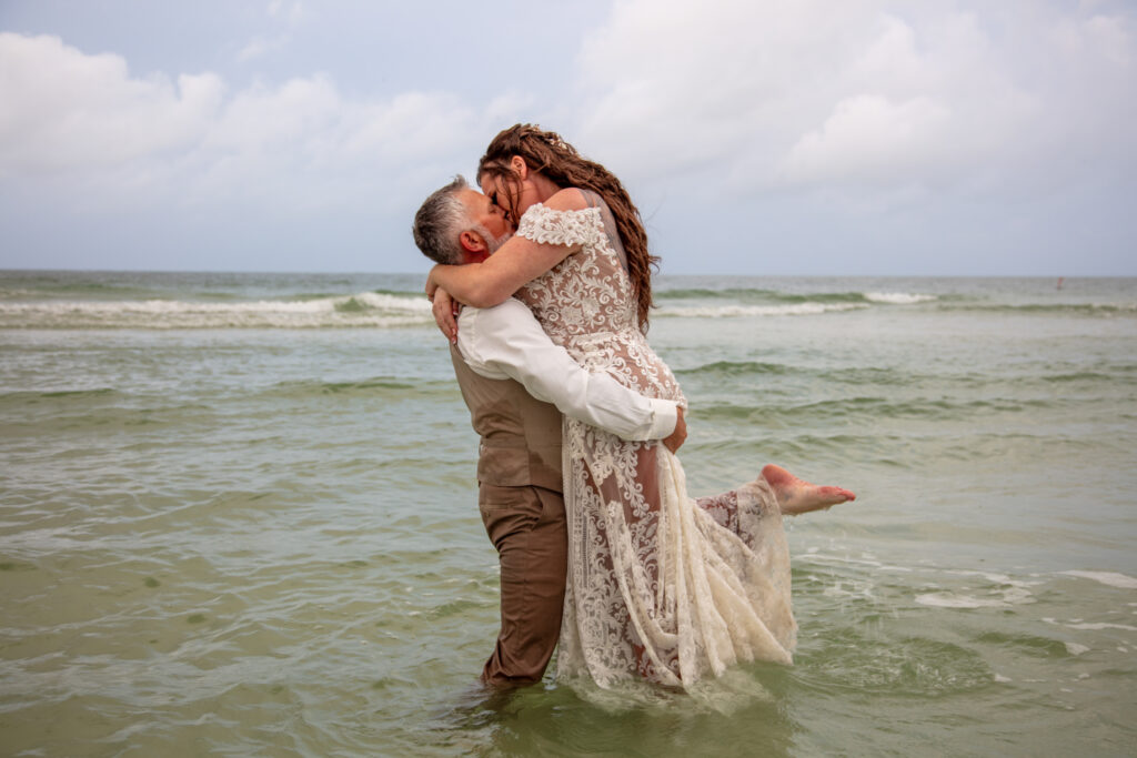 bride and groom standing in the ocean