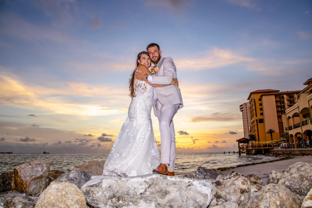 bride and groom on the beach at sunset