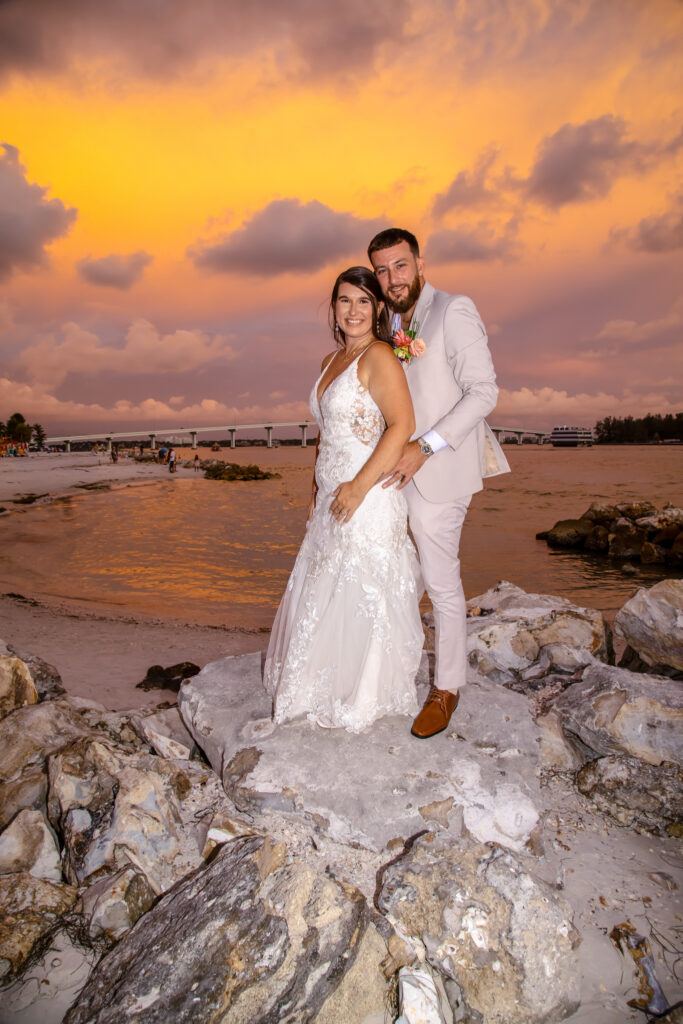 bride and groom on the beach at sunset