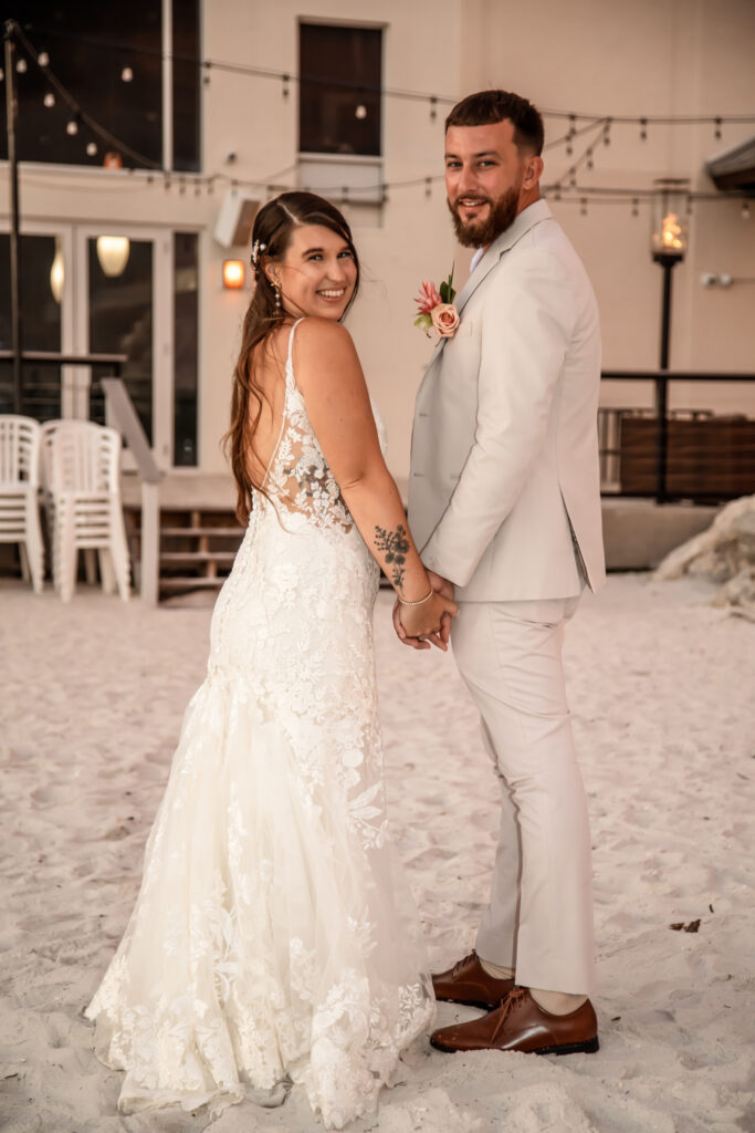bride and groom on the beach at sunset